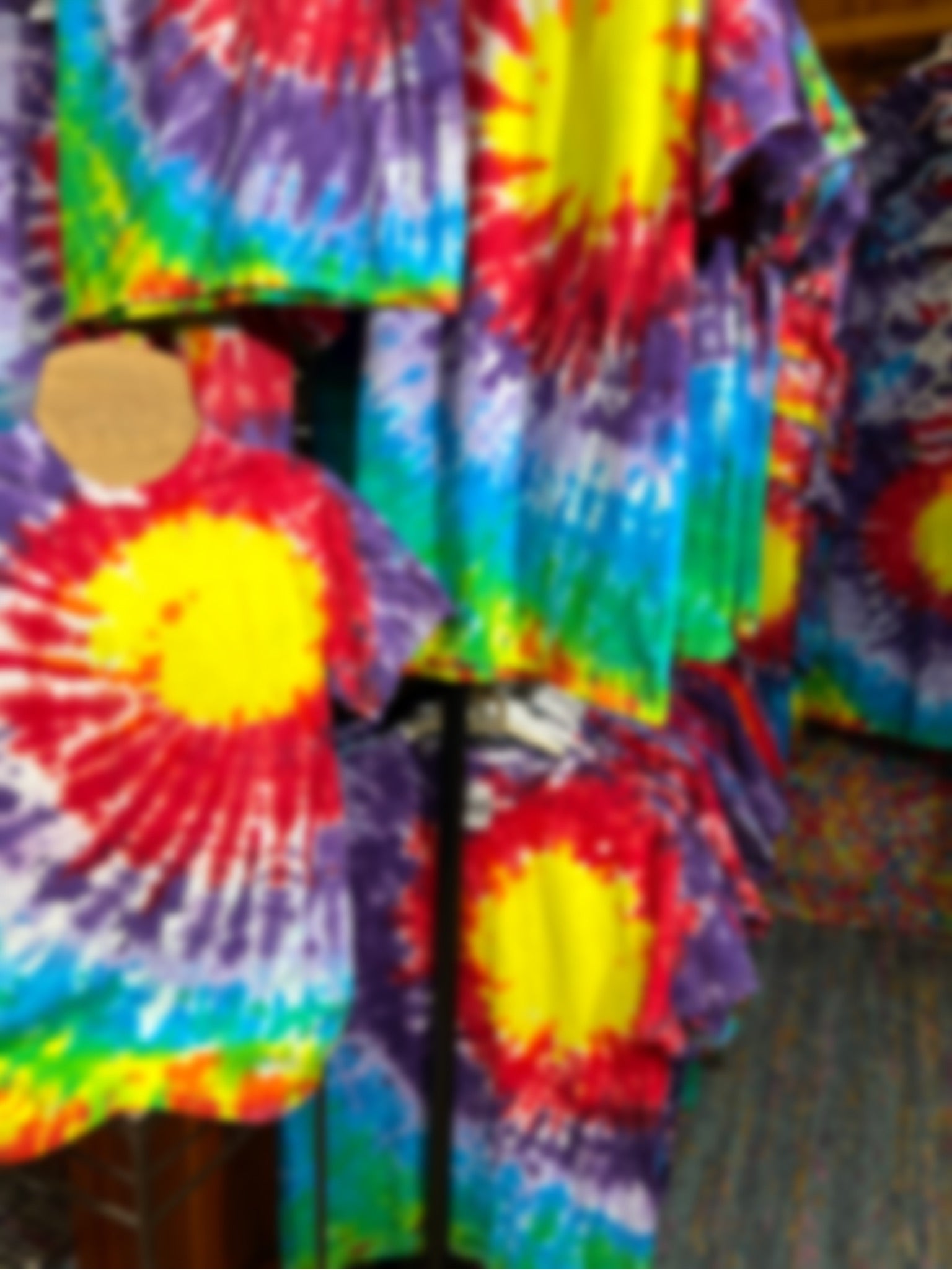 Part of a custom order for 200 logo style tie dye shirts displayed on mannequins and a clothing rack 