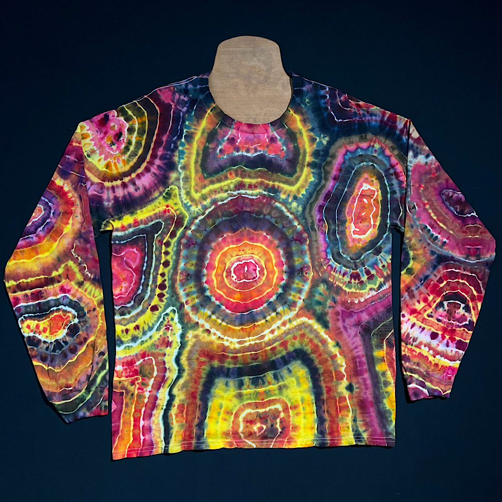 Front side of a pink, black & yellow agate geode reminiscent ice tie-dyed long sleeve shirt design; laid flat on a solid black background 
