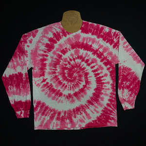 An example of a finished Bubblegum pink spiral long sleeve tie dye shirt; laid flat on a solid black background 