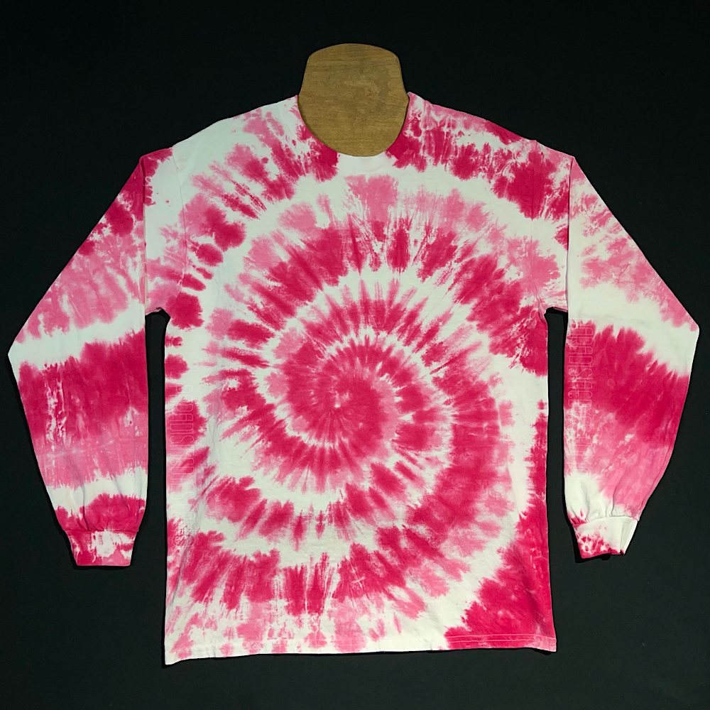 An example of a finished Bubblegum pink spiral long sleeve tie dye shirt; laid flat on a solid black background 