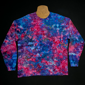 A vibrant, one-of-a-kind, pink, purple & blue marbled-splatter ice tie-dyed long sleeve shirt design; laid flat on a solid black background.