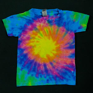 An example of a finished, handmade-to-order toddler sized neon rainbow tie dye t-shirt, featuring: pink, peach, yellow, lime green & electric blue in a spiral design; laid flat on a solid black background