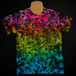 An example of a finished Midnight Marbled Rainbow Ice Dye T-Shirt; a rainbow gradient featuring: pink, orange, yellow, green & blue,with black splatter detailing
