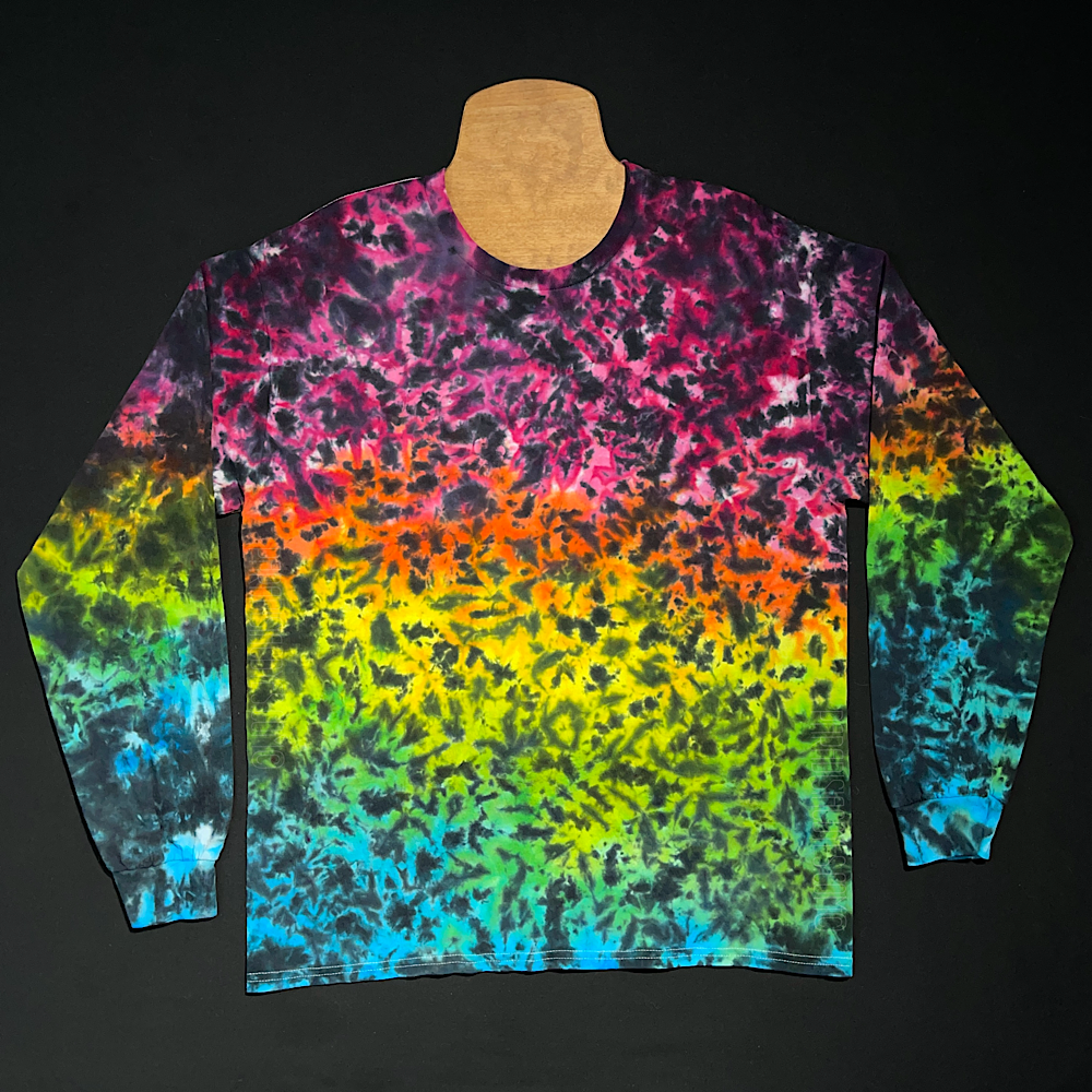 A rainbow marbled gradient design featuring (from top to bottom): pink, orange, yellow, lime green & aqua blue shades, with black splatter pattern detailing over top on a long sleeve shirt.