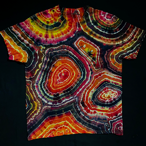 Front side of a short sleeve, crewneck style t-shirt featuring an agate geode reminiscent pattern with shades of pink, yellow & black