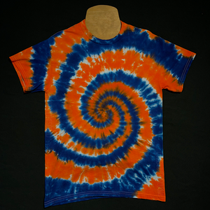 Front side of an orange & dark blue Detroit Tigers inspired short sleeve tie dye shirt design; laid flat on a solid black background 
