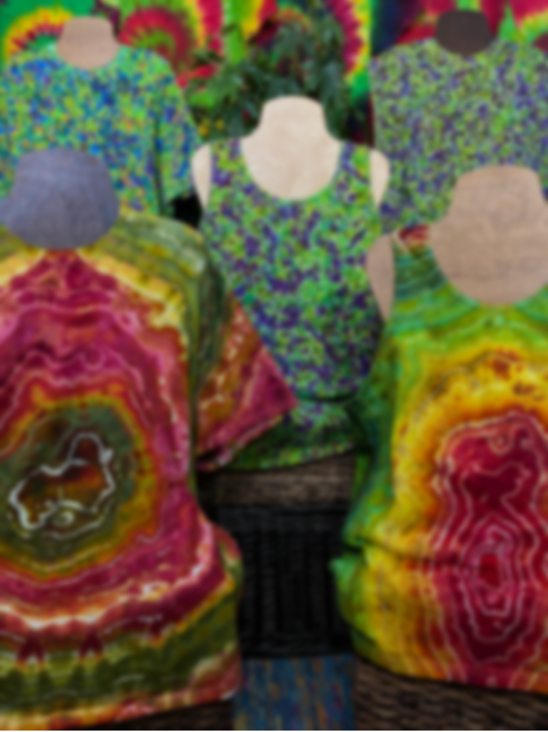 Up front are two rasta giant single geode designs, with three green and purple weed bud inspired splatter patterns behind, all five displayed on wooden mannequins 