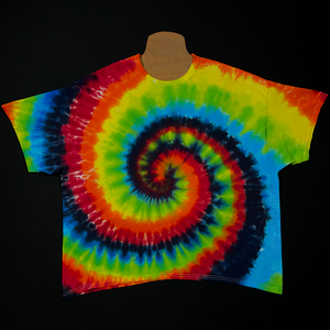An example of a finished black rainbow spiral tie dye t-shirt design; featuring shades of: red, orange, yellow, green, blue with black