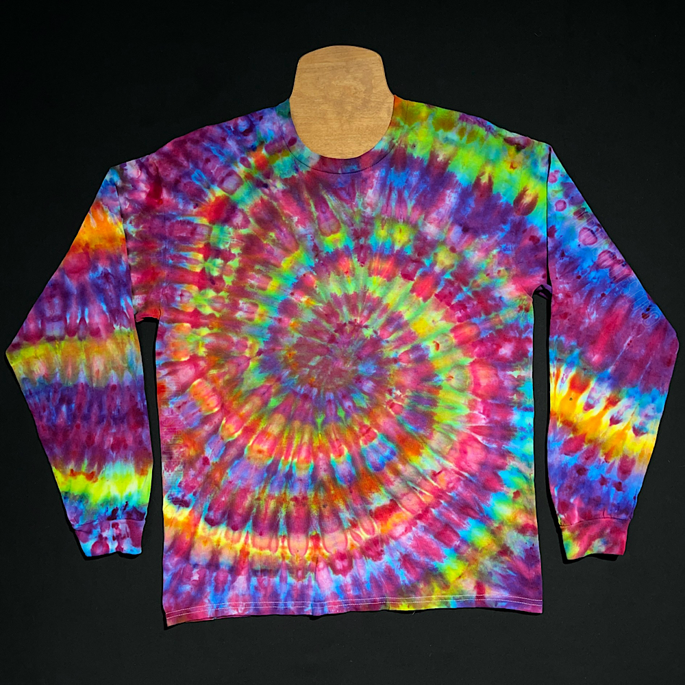An ice tie-dyed rainbow spiral long sleeve shirt design featuring a primarily pink color scheme; laid flat on a solid black background.
