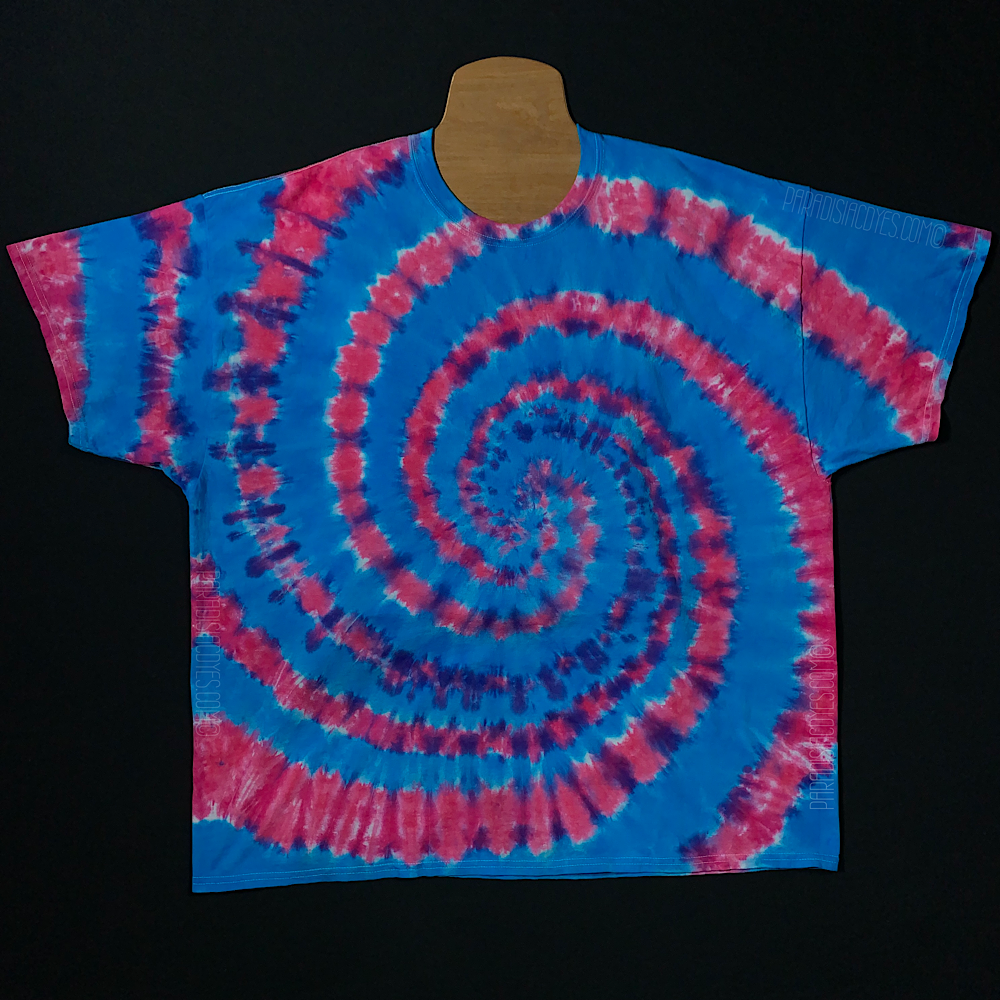 An example of a finished blue & pink cotton candy spiral short sleeve tie dye shirt design; laid flat on a solid black background 