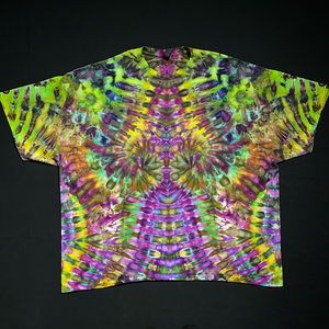 An example of a finished green and purple abstract, symmetrical Hippieween ice tie-dyed t-shirt design; laid flat on a solid black background.