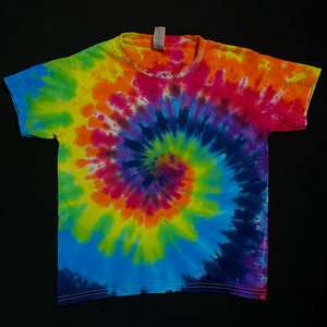 A different, finished, one-of-a-kind ROYGBIV rainbow spiral tie dye t-shirt design in a youth size; laid flat on a solid black background 