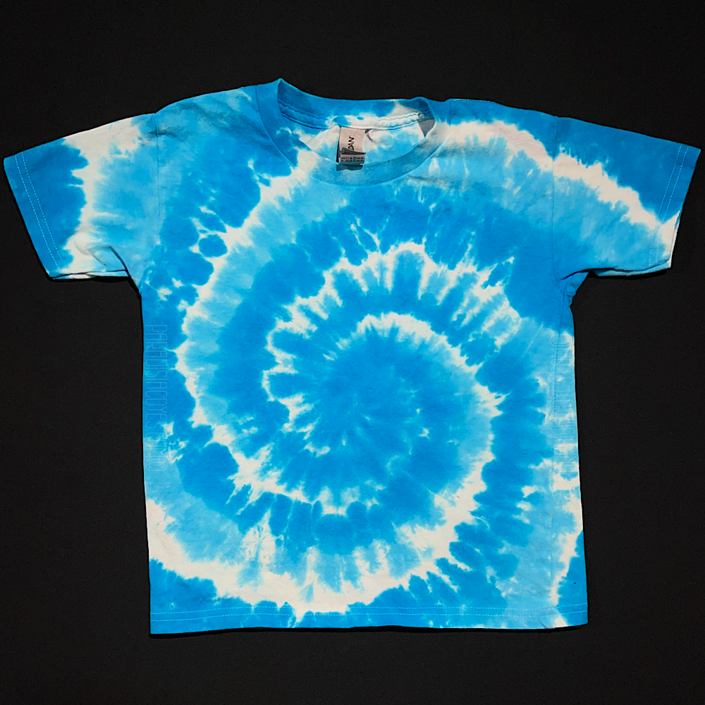 A duo-toned blue spiral tie dye toddler sized short sleeve shirt; laid flat on a solid black background 
