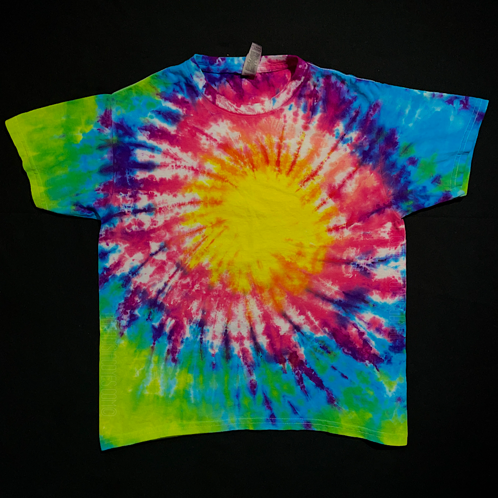 An example of another finished Neon Rainbow Sunburst short sleeve youth/toddler sized tie dye shirt; laid flat on a solid black background