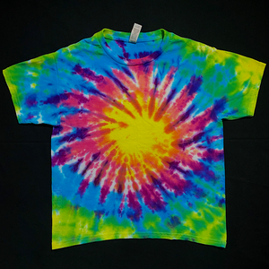 An example of a finished, hand-dyed, one-of-a-kind Neon Rainbow Sunburst short sleeve tie dye shirt design in a children's size; laid flat on a solid black background
