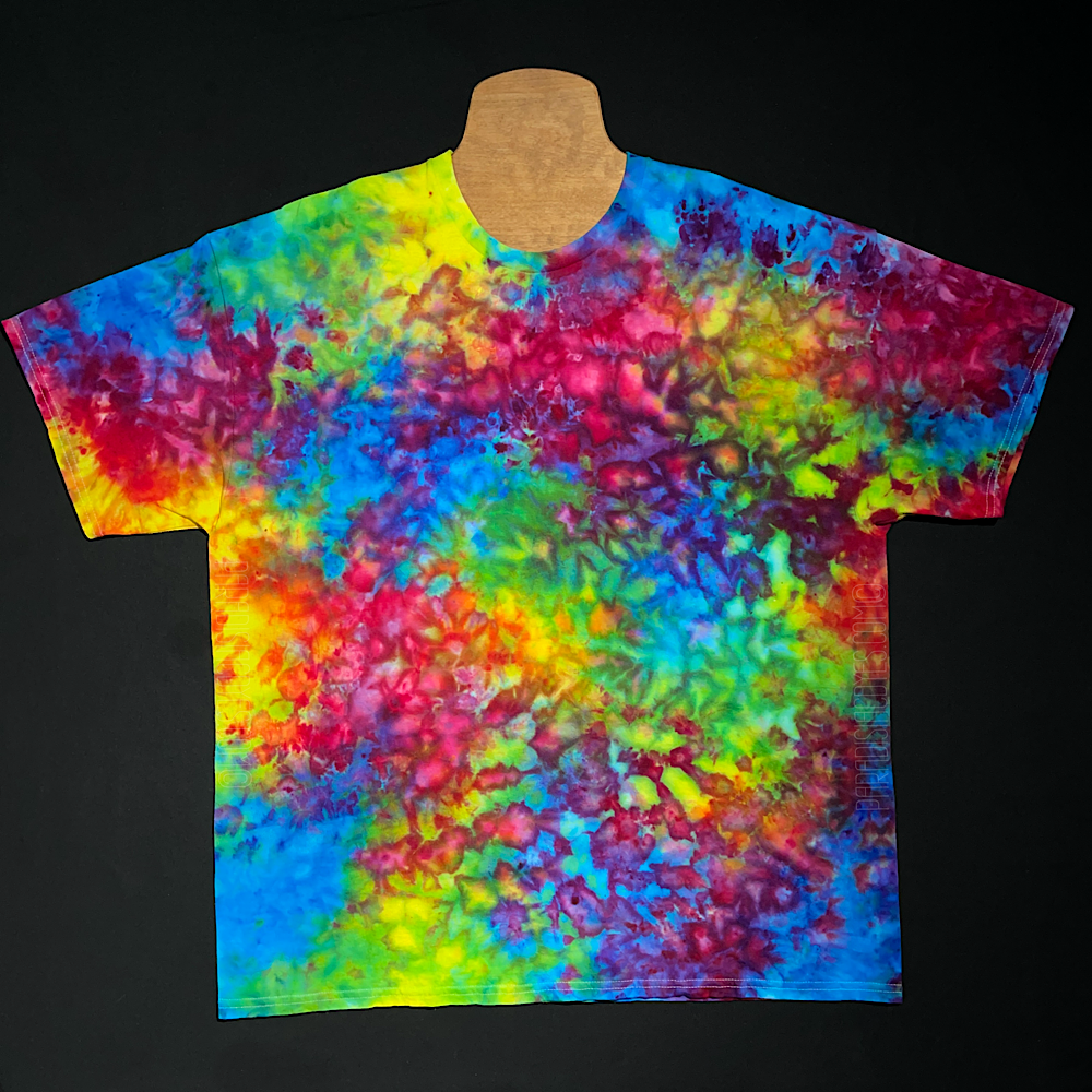 A blue, pink & yellow Superman ice cream color inspired marbled splatter pattern ice tie-dyed short sleeve shirt design, laid flat on a solid black background.