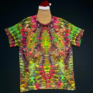 Front side of a red & green, Christmas color inspired, abstract, symmetrical, ice tie-dyed t-shirt design; laid flat on a solid black background