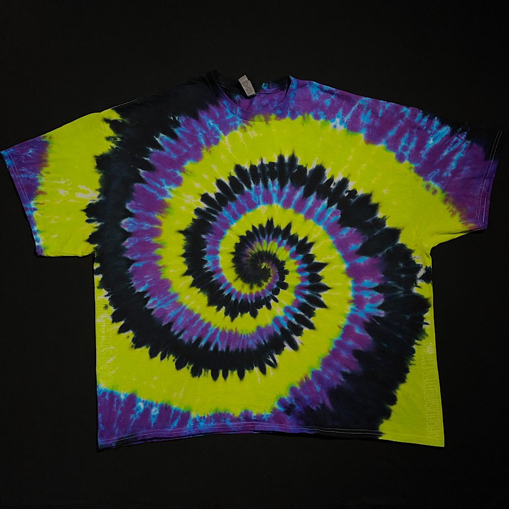 An example of an actual, finished Black, Green & Purple Spiral Tie Dye T-Shirt design before shipping; laid flat on a solid black background