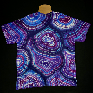 Back side of a Purple Amethyst Quartz Agate Geode tie dye short sleeve shirt; laid flat on a solid black background