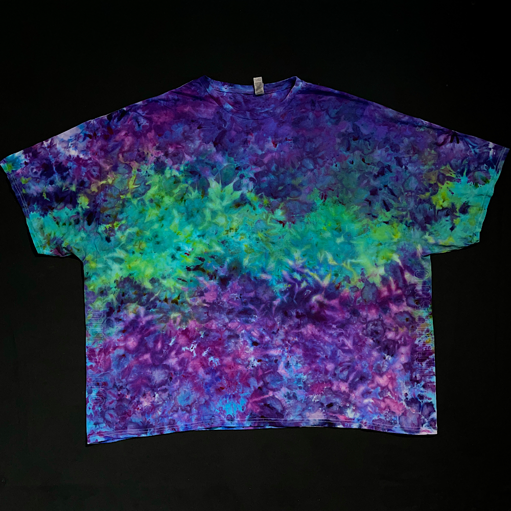 Front side of a purple & mint green marbled ice tie-dyed short sleeve shirt design; laid flat on a solid black background 