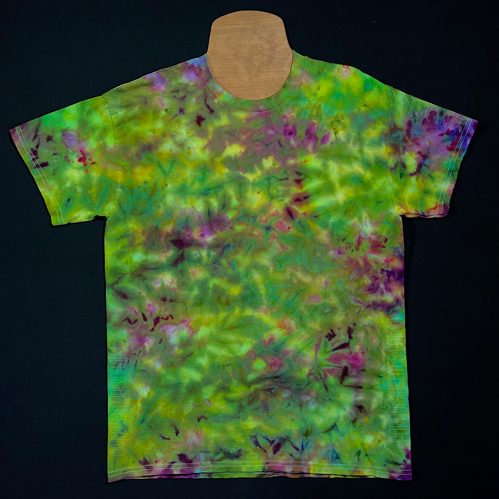An example of a finished, one-of-a-kind, weed bud inspired green & purple marbled ice tie-dyed t-shirt design; laid flat on a solid black background 