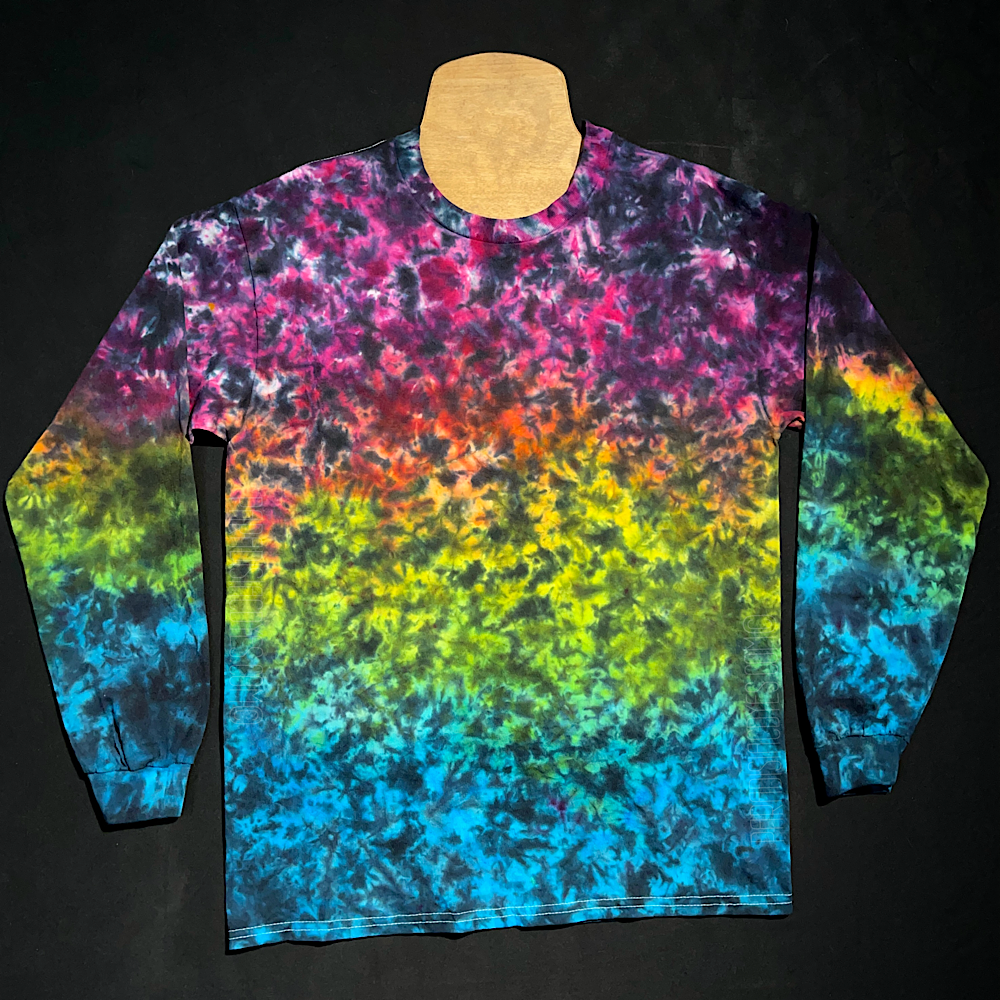 A rainbow marbled gradient design featuring (from top to bottom): pink, orange, yellow, lime green & aqua blue shades, with black splatter pattern detailing over top on a long sleeve shirt.