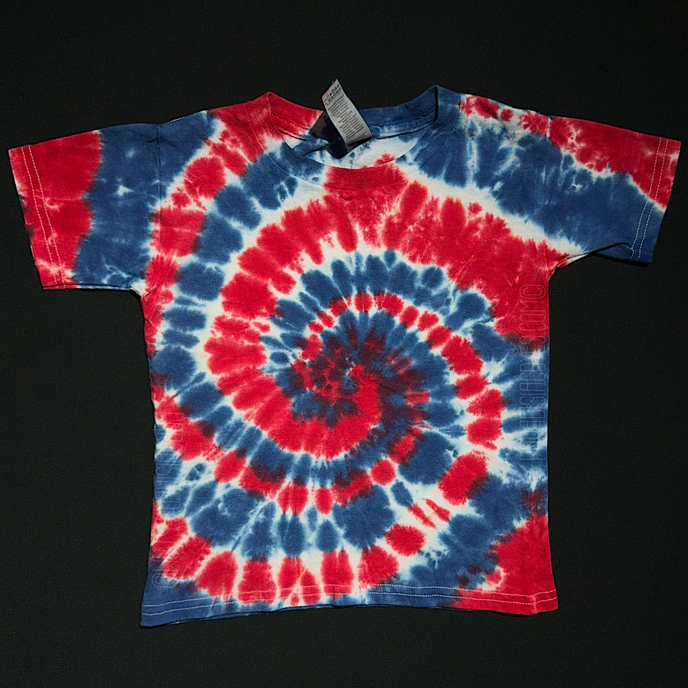 A toddler sized short sleeve shirt featuring a red, white & blue spiral tie dye design.