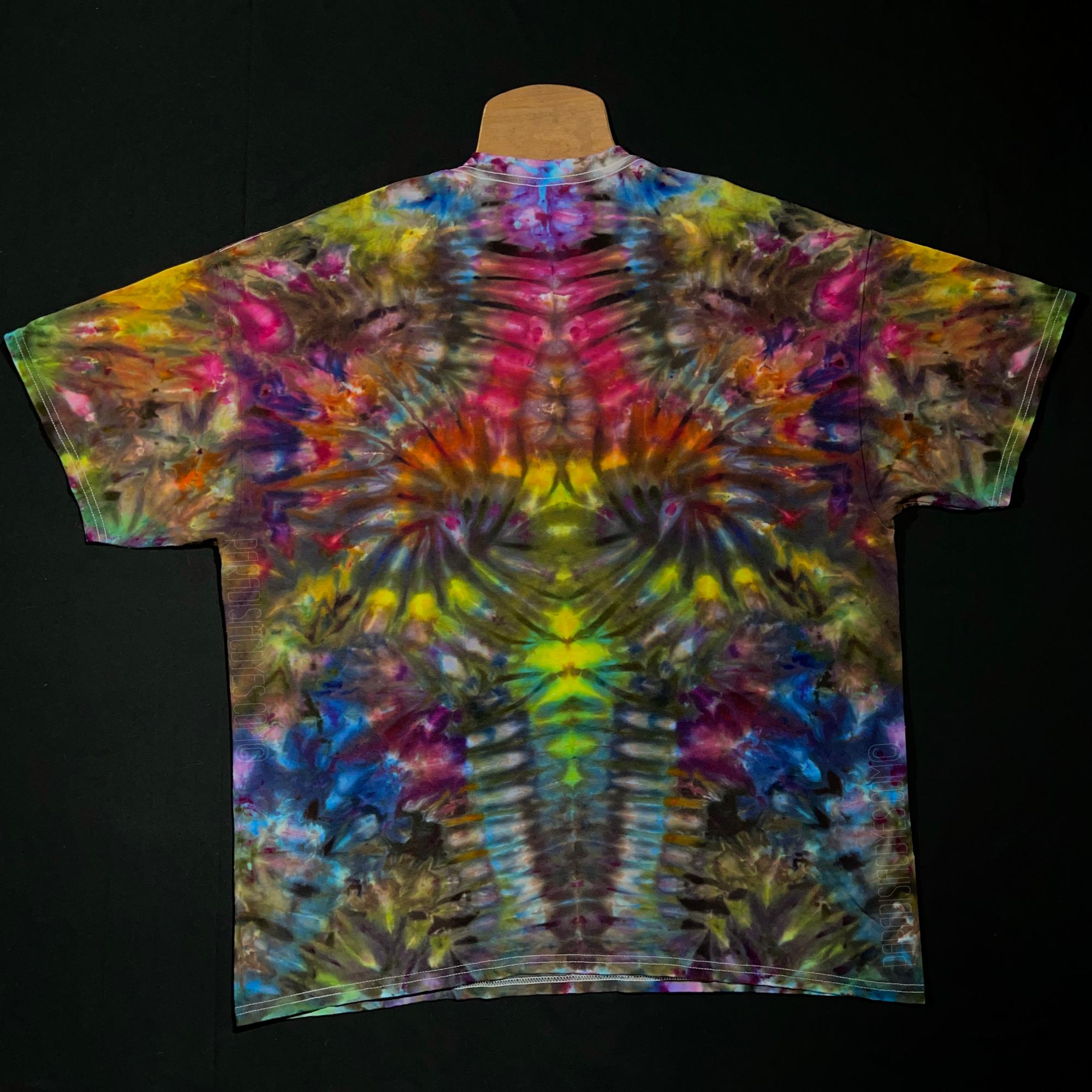 Front side of a size xxl psychedelic mindscape ice tie-dyed short sleeve shirt design that features a vibrant array of rainbow colors throughout the totem pole reminiscent pattern