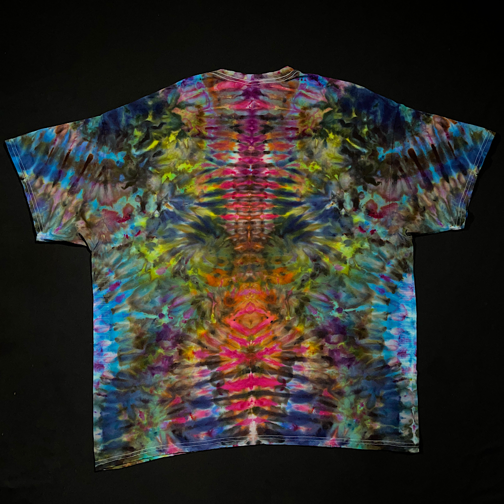 Front side of an ice tie-dyed t-shirt design featuring an abstract, symmetrical, rainbow ice tie-dyed design; laid flat on a solid black background 