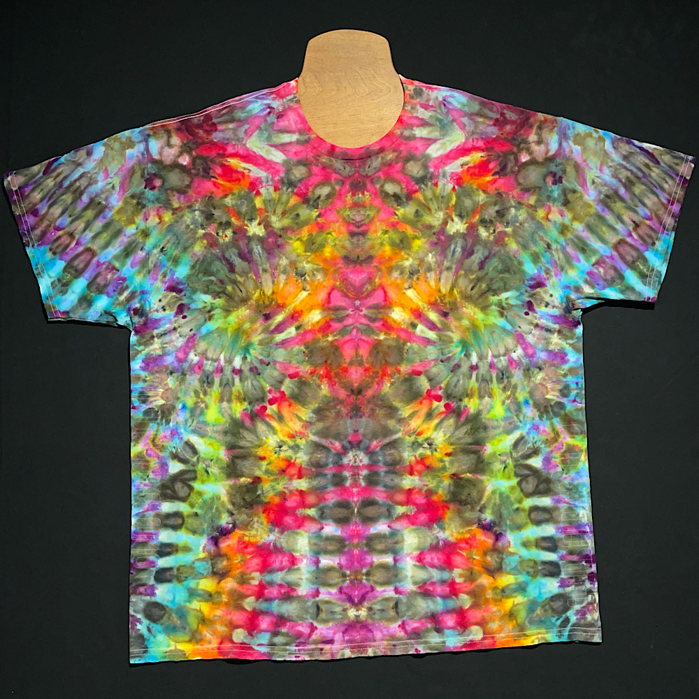 Front side of a one-of-a-kind, abstract, rainbow ice tie-dyed t-shirt design; laid flat on a solid black background.