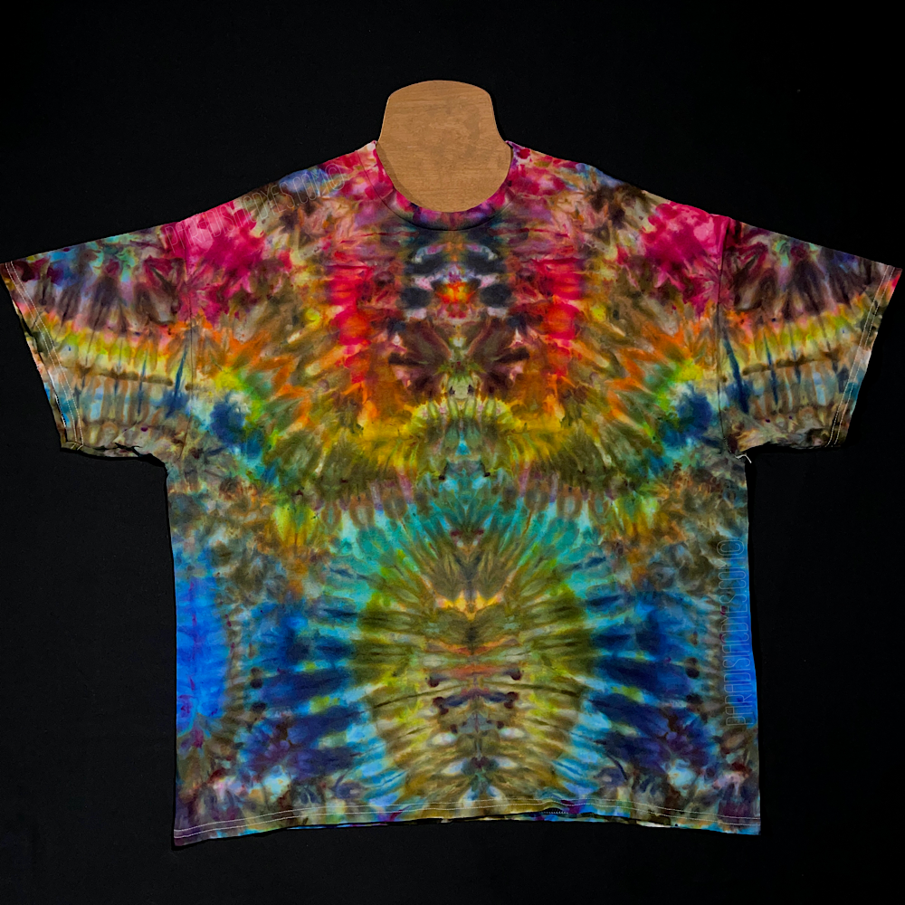 Front side of a symmetrical rainbow ice tie-dyed short sleeve shirt design that features a cascading gradient of: red, orange, yellow, green, turquoise & blue shades from top to bottom; laid flat on a solid black background