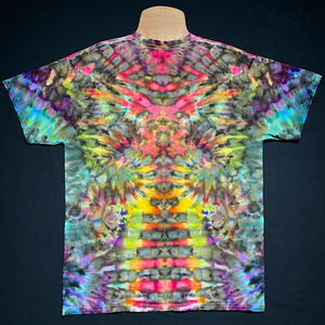 Back side of a one-of-a-kind, abstract, symmetrical rainbow ice tie-dyed short sleeve shirt; laid flat on a solid black background.