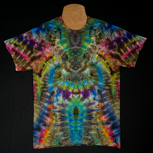 Front side of a multicolored rainbow psychedelic mindscape ice tie-dyed shirt design featuring an abstract, symmetrical pattern; laid flat on a solid black background 