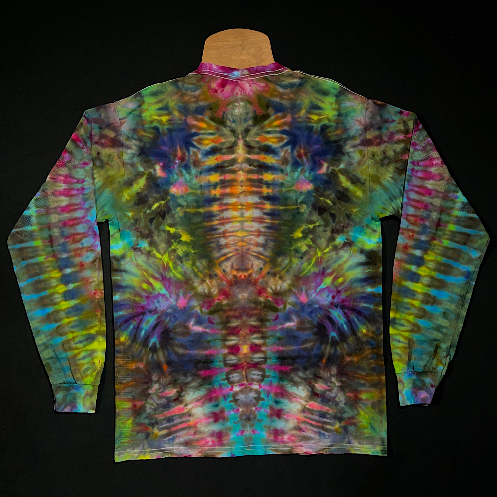 Back side of a multi-colored long sleeve shirt featuring an abstract, symmetrical, totem pole reminiscent ice tie-dyed design; laid flat on a solid black background 