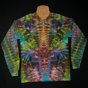 Front side of a multi-colored long sleeve shirt featuring an abstract, symmetrical, totem pole reminiscent ice tie-dyed design; laid flat on a solid black background 