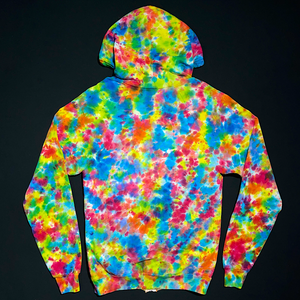 Back side of a size adult small American Apparel zip-up hoodie, with the hood up, featuring a hand-dyed, one-of-a-kind rainbow splatter pattern tie dye design, laid flat on a solid black background.
