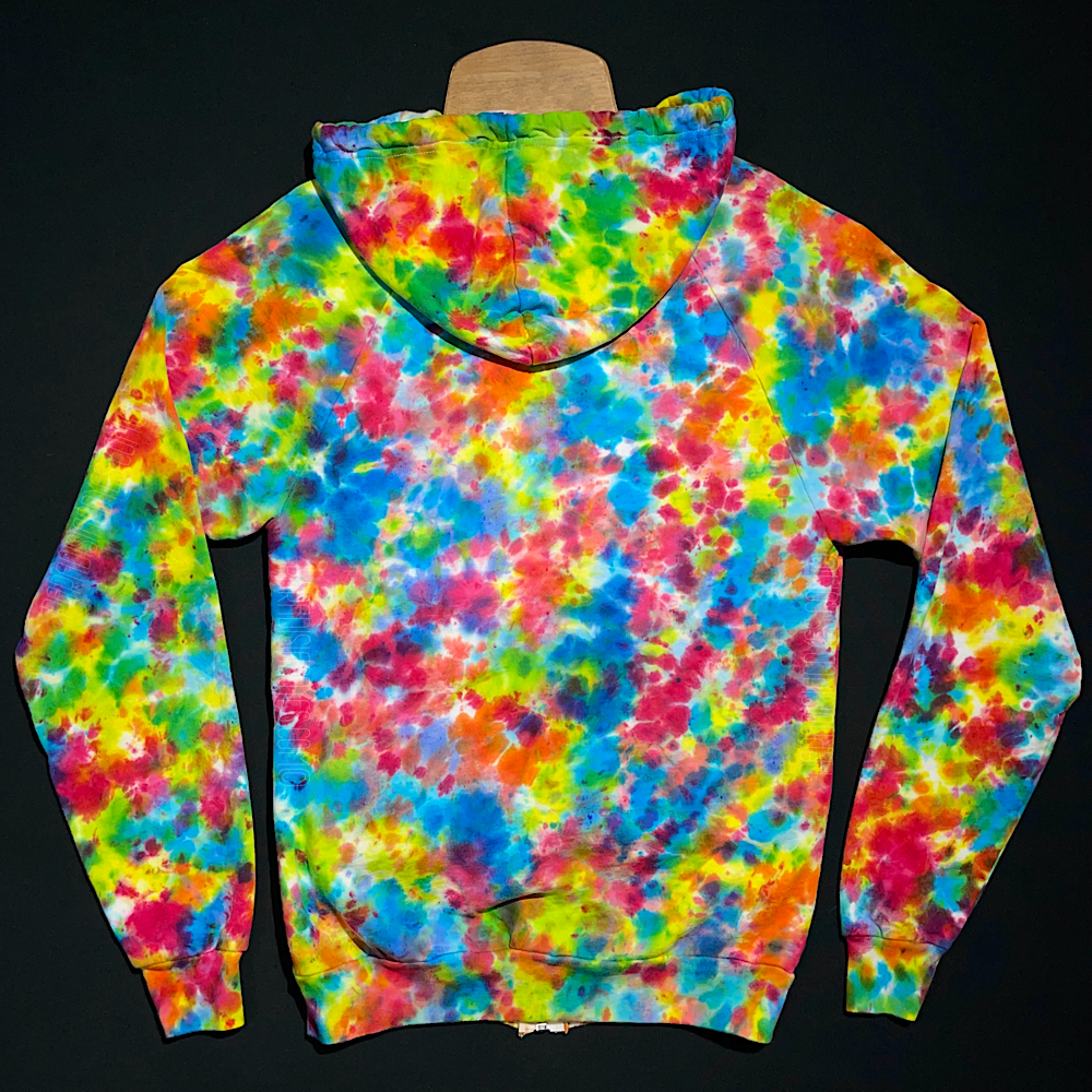 Front side of a zip-up hoodie featuring a hand-dyed, one-of-a-kind rainbow splatter pattern tie dye design, laid flat on a solid black background.