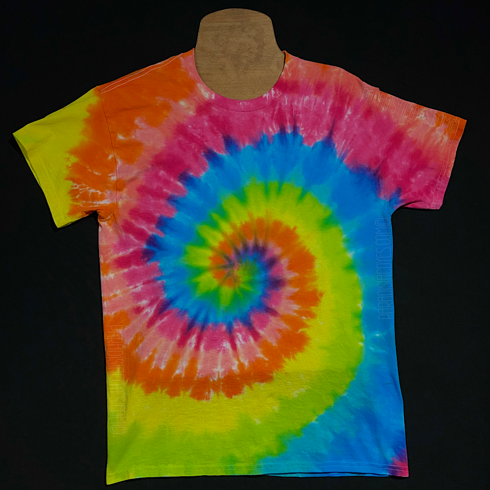 Front side of a neon rainbow spiral short sleeve tie dye shirt; laid flat on a solid black background