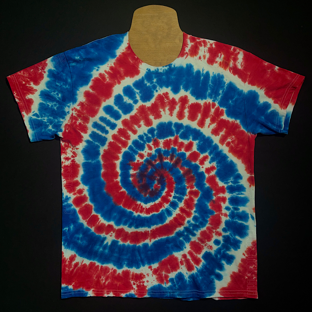 An example of a finished red, white & blue spiral short sleeve tie dye t-shirt design; laid flat on a solid black background