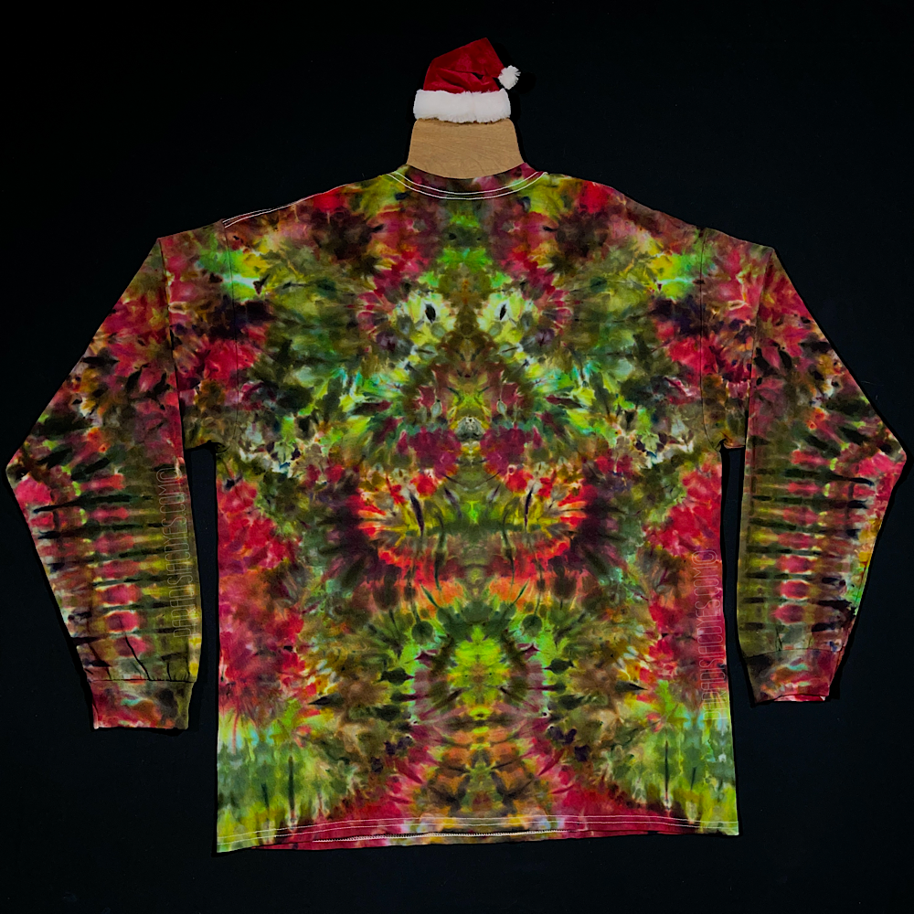 Back side of a Merry Mindscape Christmas inspired ice tie dyed long sleeve shirt design. An abstract, symmetrical, pareidolia inducing pattern featuring an array of festive red, green & gold shades.