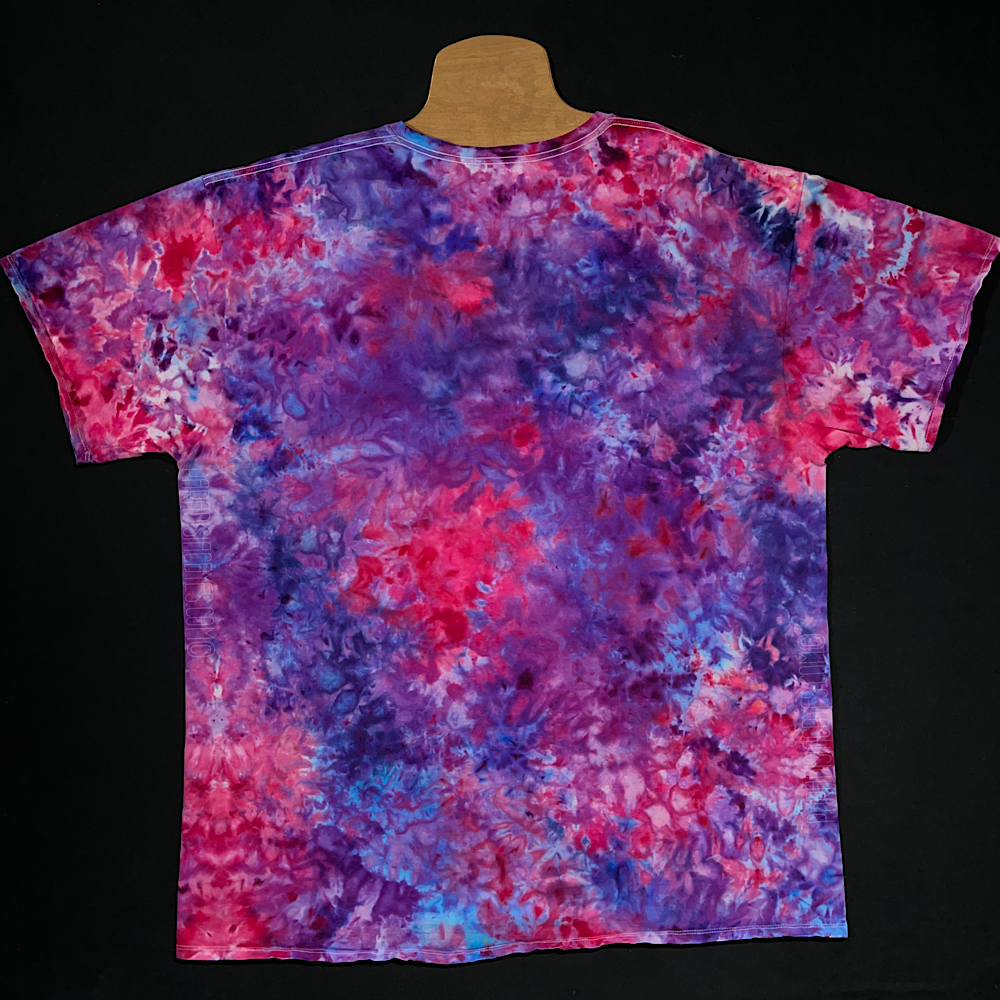Back side of a made-to-order pink & purple marbled ice dye splatter t-shirt design; laid flat on a solid black background 