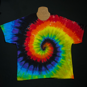 Front side of a rainbow spiral short sleeve tie dye shirt featuring: red, orange, yellow, green, blue, violet, and black in a spiral design; pictured laying flat on a solid black background