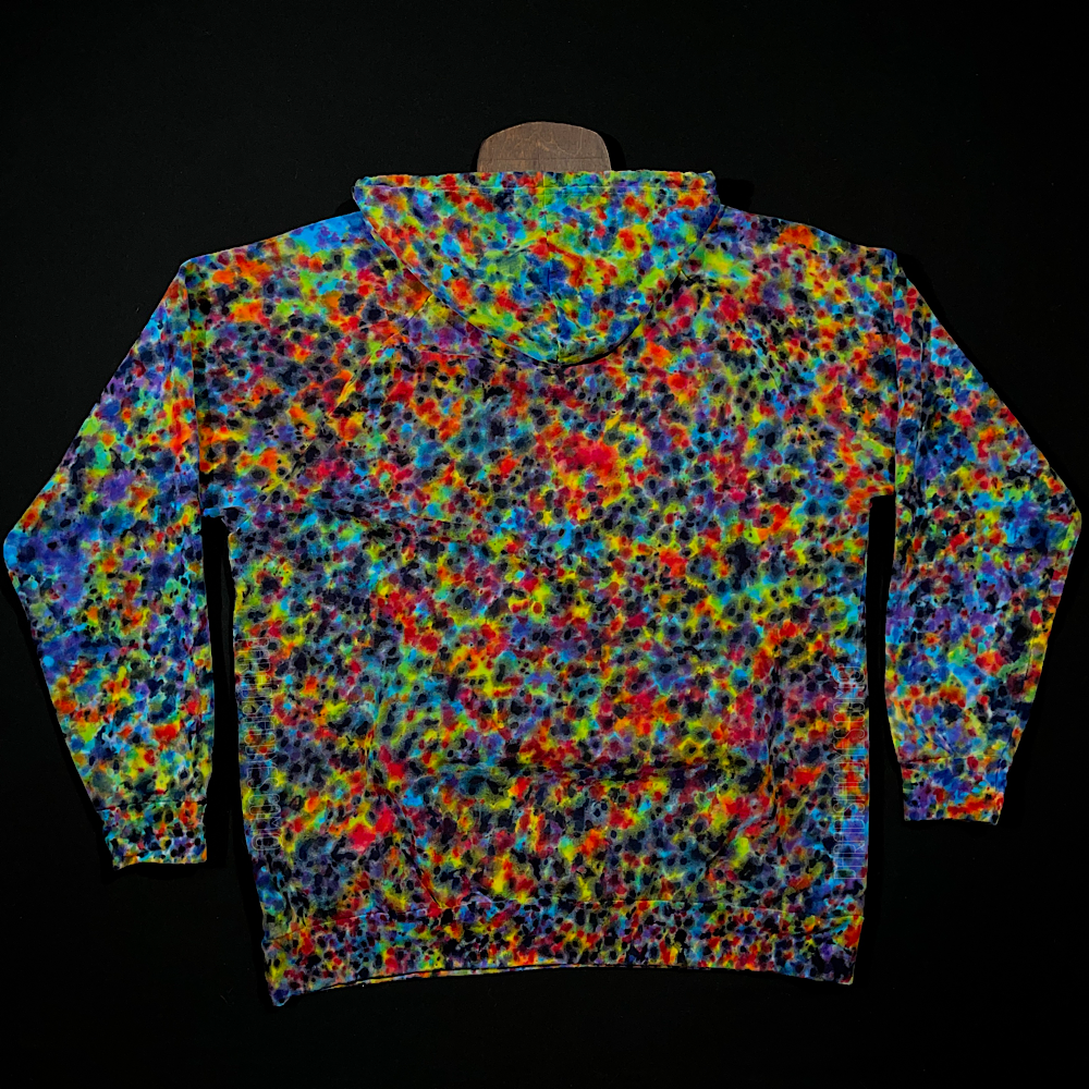 Back side of a pullover style tie dyed hoodie featuring vibrant rainbow colors in a paint splatter reminiscent, speckled design