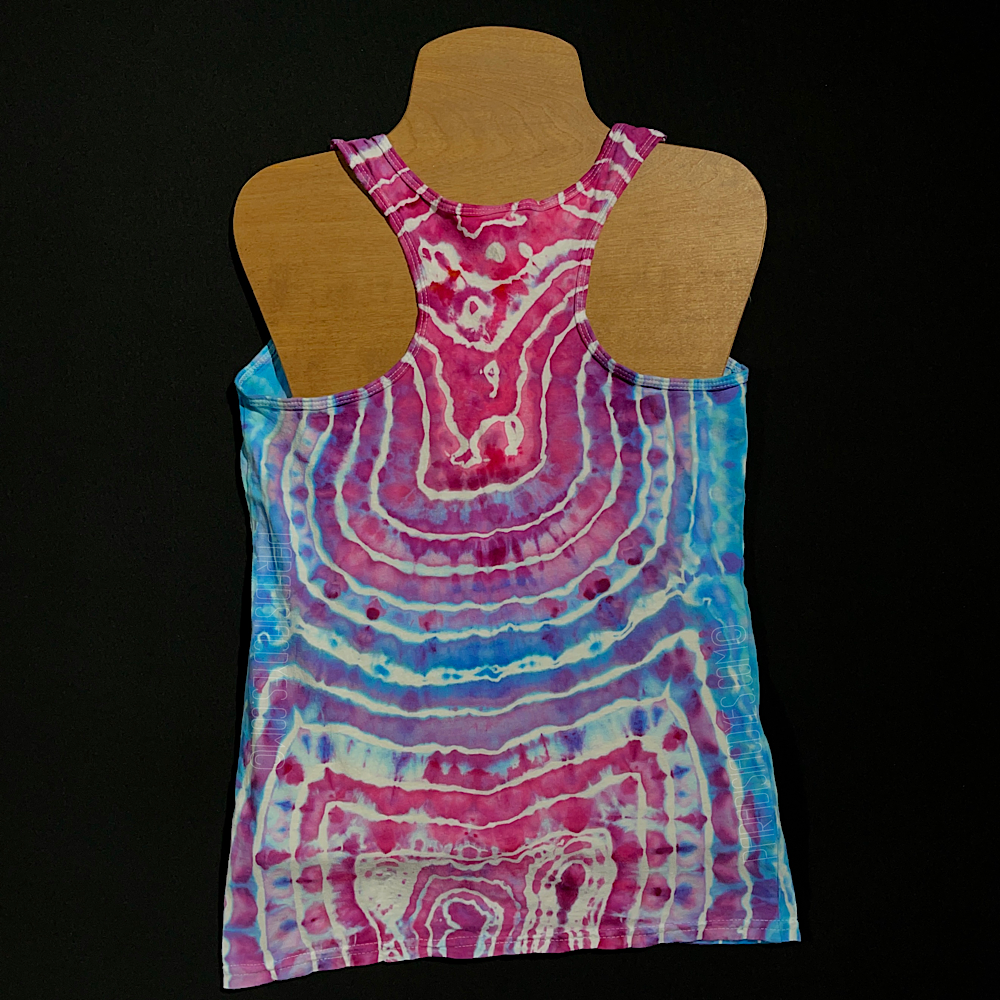 Front side of a ladies' racerback style tank featuring an agate geode inspired ice dyed design, with a giant, single vertical, oblong geode on the front featuring a hot pink center, transitioning to dreamy, baby blue shades as the bands expand outward 