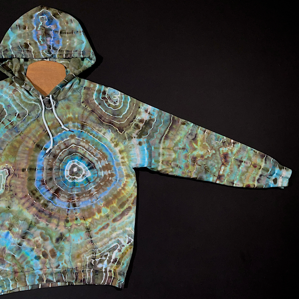 The fully extended front left side sleeve of the size XL pullover hoodie in an agate geode inspired ice dye design